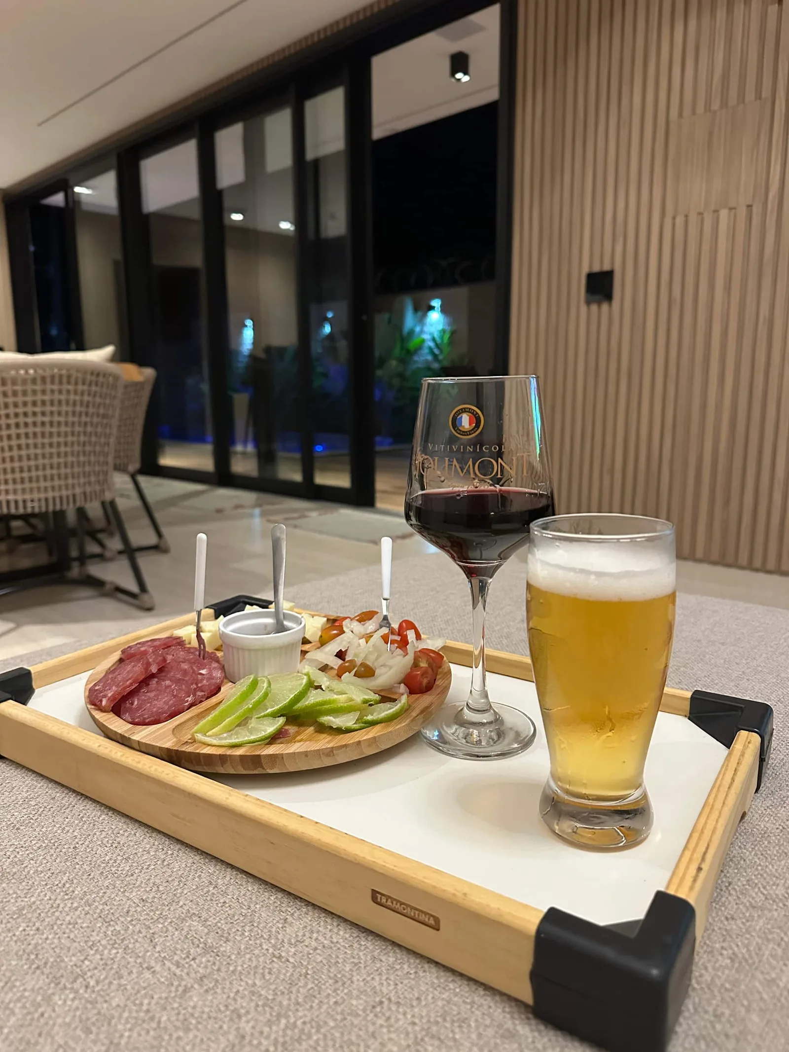 Tábua de frios e cerveja gelada servidas na mesa de jantar