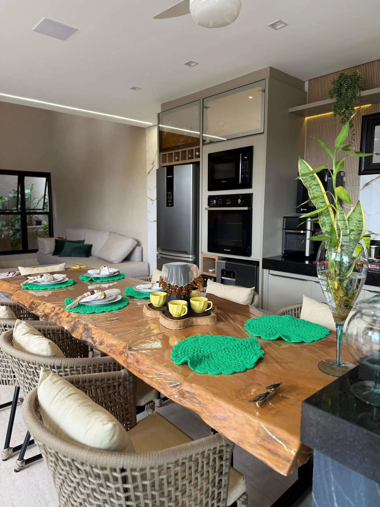 Mesa posta com jogo americano verde-esmeralda e flor de corte