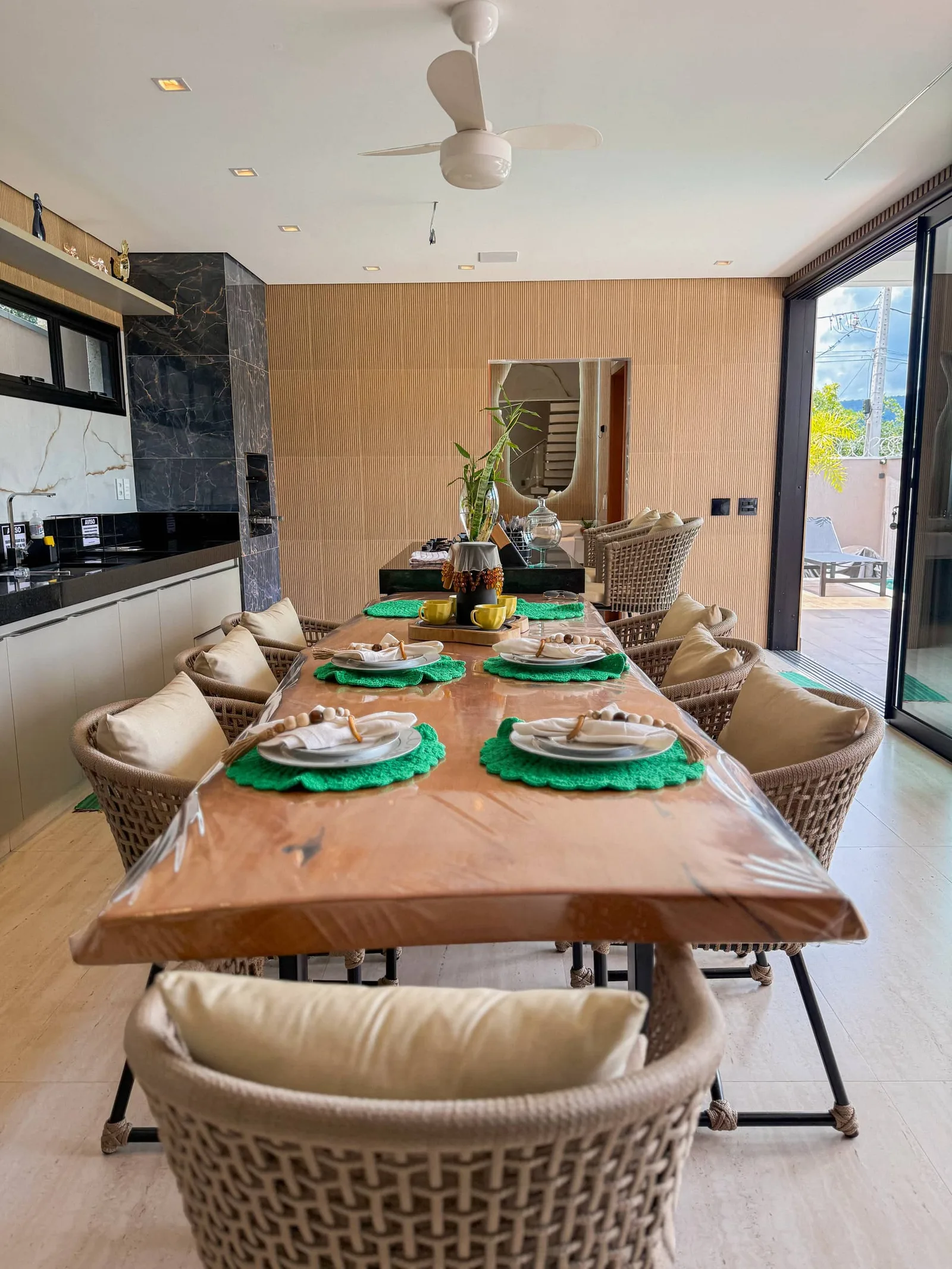 A sala de jantar em plano aberto, cadeiras de fibra ao redor da mesa
