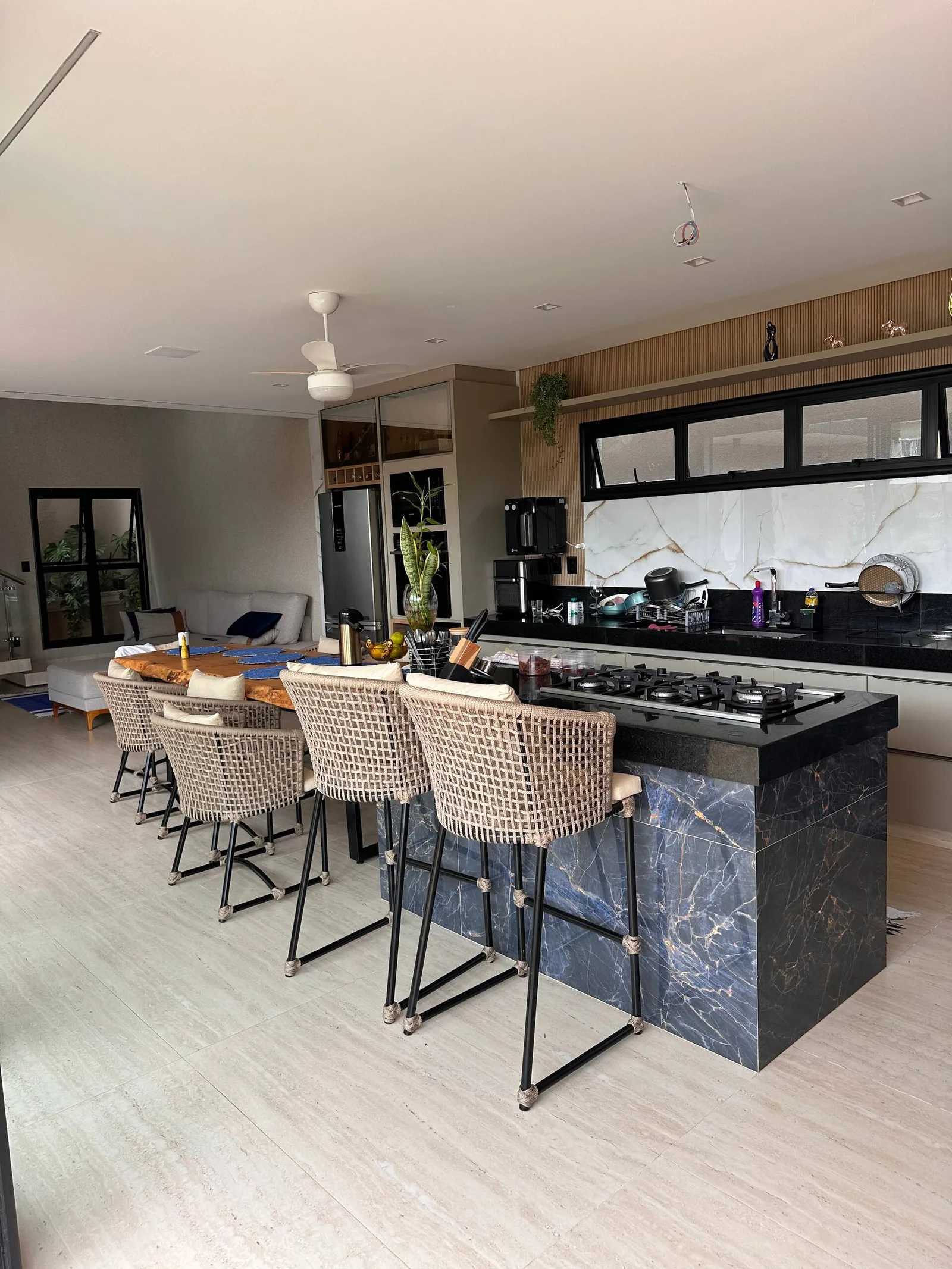 Balcão da cozinha americana com banquetas voltadas para a mesa